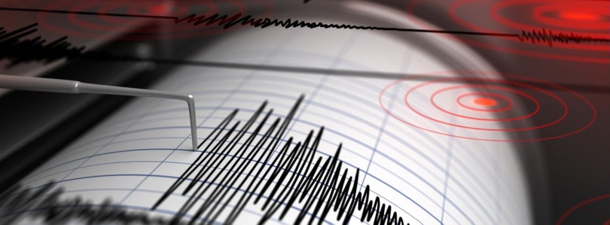 A seismograph records jagged black lines indicating an earthquake. Red concentric circles overlay suggest epicenters, creating a sense of intensity.