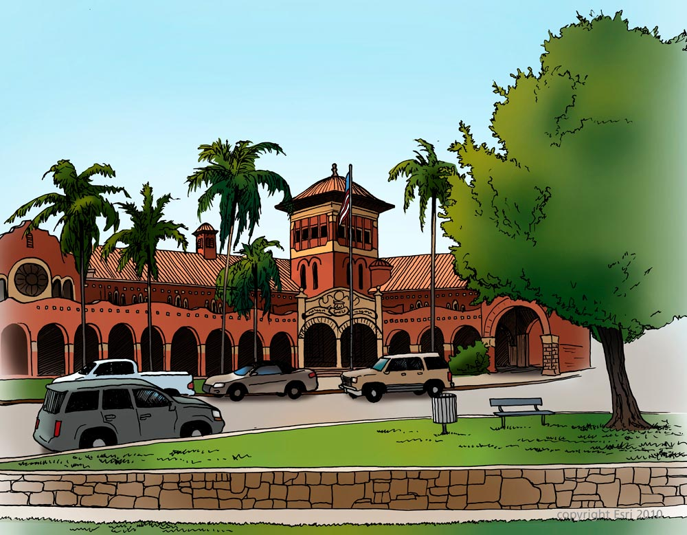 Red-brick building with arches and palm trees under a blue sky. Cars parked in front, and a green lawn with a bench and tree on the right.
