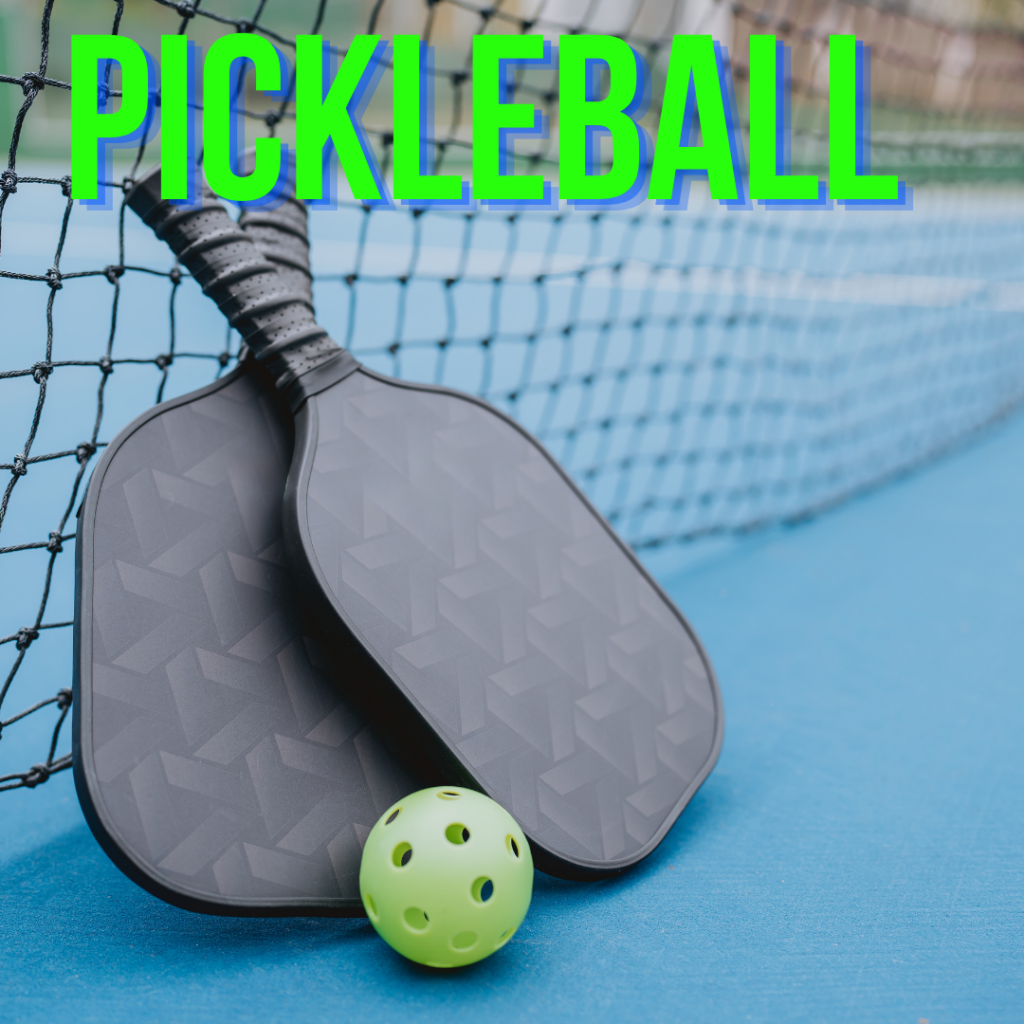 Two black pickleball paddles and a green perforated ball lie on a blue court near the net. The word “PICKLEBALL” is displayed in bold green text at the top.